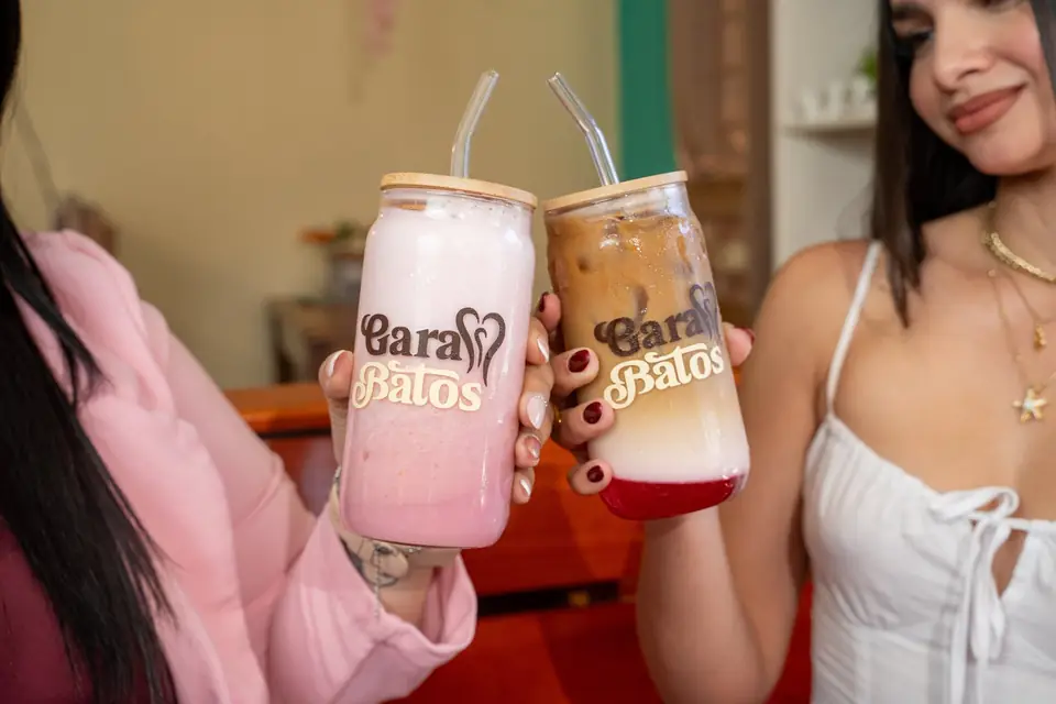 Two friends toasting with smoothies in Garabatos glasses