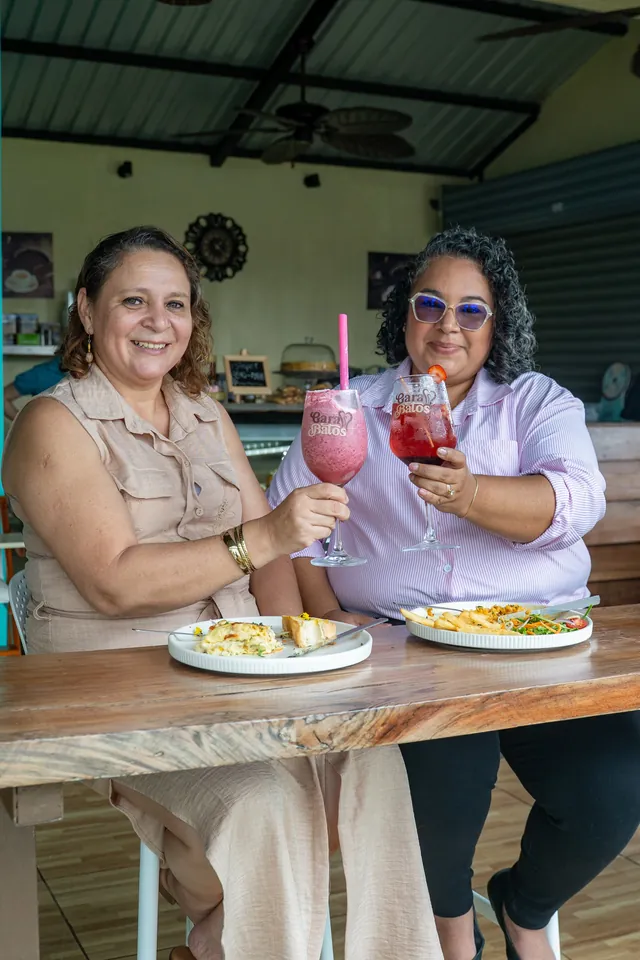 Two friends toasting with fresh drinks at Garabatos
