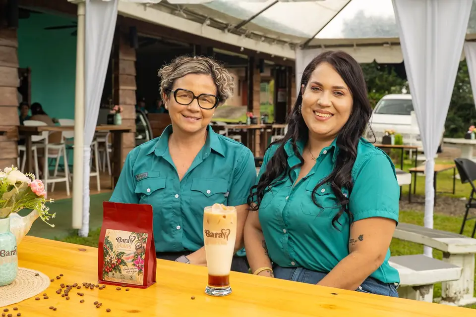 Two members of the Garabatos team at the bar with coffee and a bag of beans