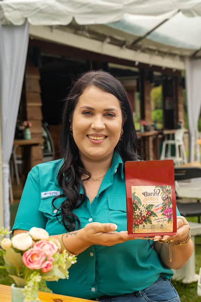 Garabatos team member holding a bag of house coffee